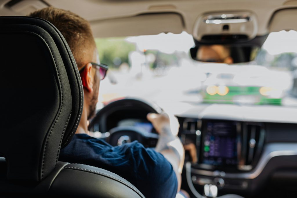 view from the back seat showing the driver and a car stopped in front