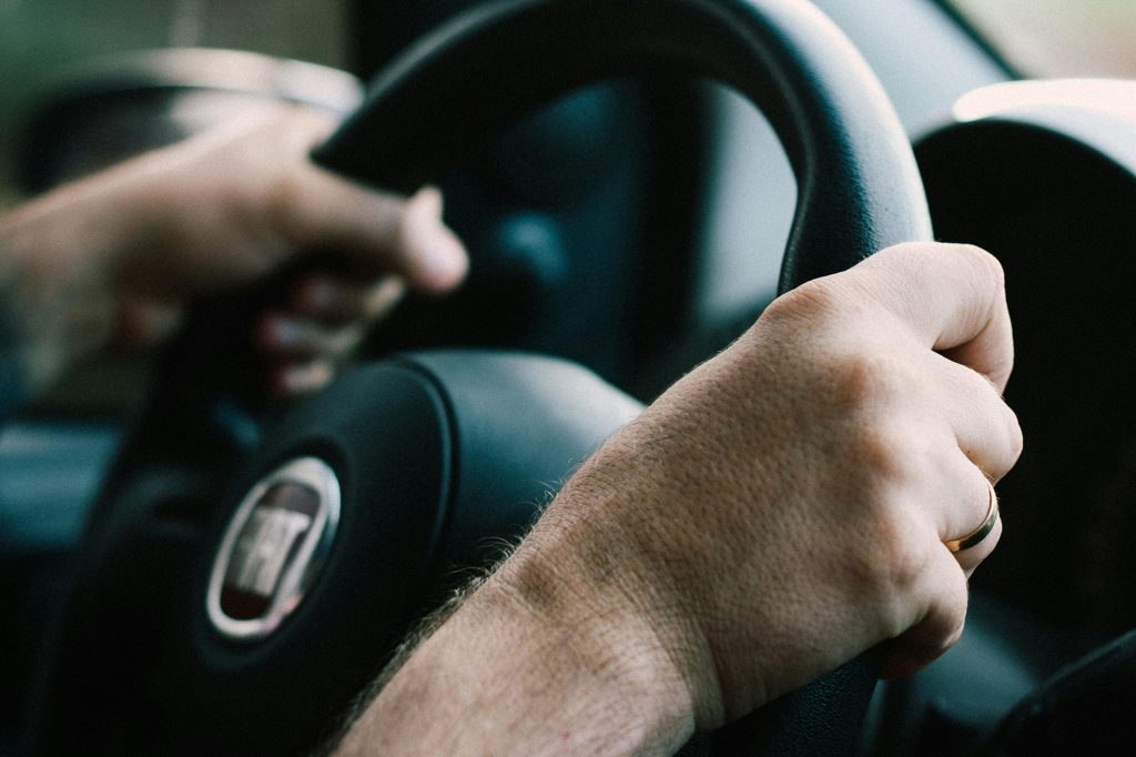 close-up of hands gripping a steering wheel